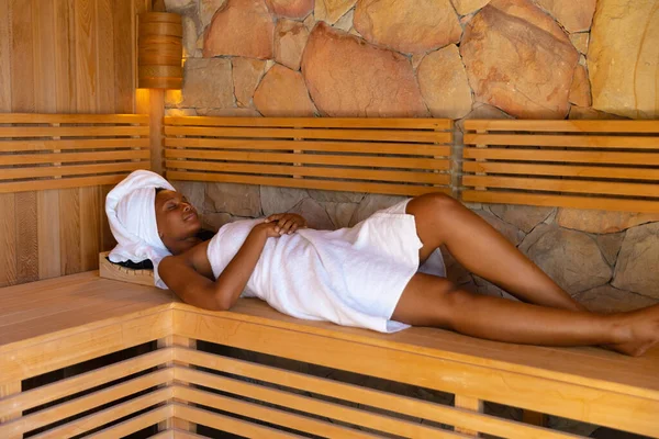 穿着浴衣在桑拿放松的非洲裔美国女人 健康和放松的概念 — 图库照片