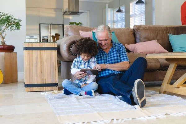 Sorrindo Avô Multirracial Usando Tablet Digital Enquanto Sentado Com Neto — Fotografia de Stock