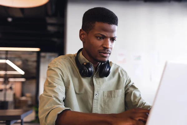 Afrikanischer Junger Geschäftsmann Mit Kopfhörern Und Laptop Kreativen Büro Unverändertes — Stockfoto