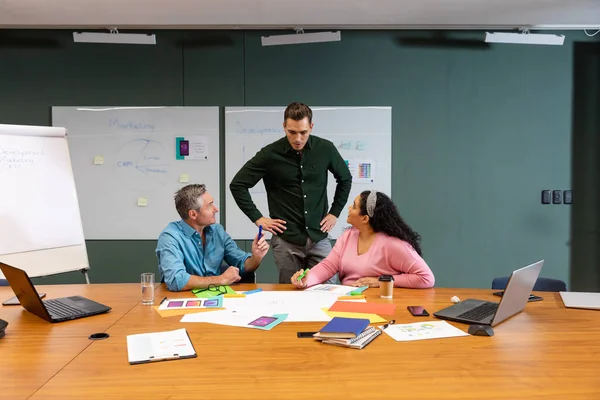 经理看着多种族同事在创意办公室讨论策略 未经改动的 创造性的业务 工作场所 多样性 — 图库照片