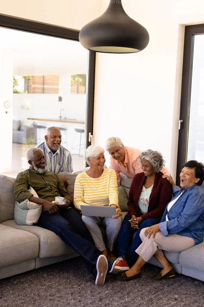 老人ホームでソファに座っている間 ラップトップ笑いで多人種の陽気な先輩の友人 無線技術 コーヒー 生活や退職の概念を支援 — ストック写真