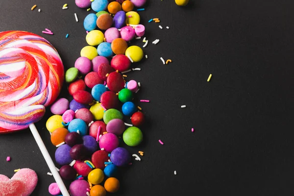 Bovenaanzicht Van Lolly Met Kleurrijke Snoepjes Sprinklers Door Kopieerruimte Zwarte — Stockfoto