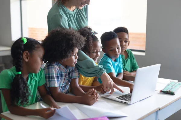 Biała Młoda Nauczycielka Wskazująca Laptopa Ucząc Afrykańskich Amerykańskich Uczniów Niezmieniony — Zdjęcie stockowe