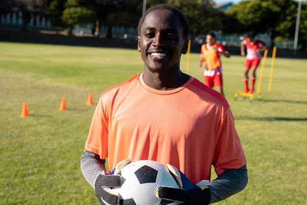Portret Afrykańskiego Uśmiechniętego Bramkarza Rękawiczkach Trzymającego Piłkę Placu Zabaw Szczęśliwy — Zdjęcie stockowe