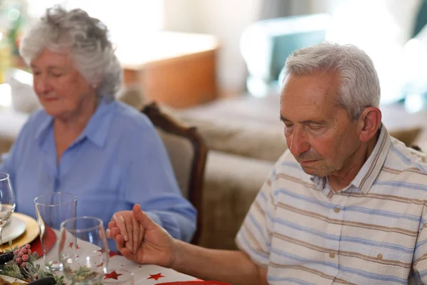 一对年长的高加索夫妇坐在桌旁 在晚饭前闭上眼睛祈祷 高质量的生活方式家庭团聚时间 — 图库照片