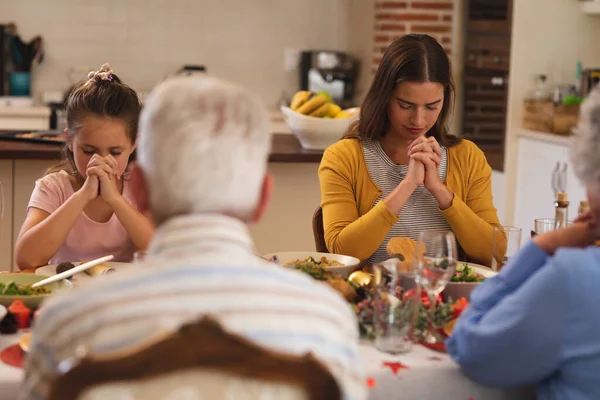 多世代の白人家族が一緒にクリスマスディナーのテーブルに座って祈っています クリスマスには質の高いライフスタイルの家族で — ストック写真