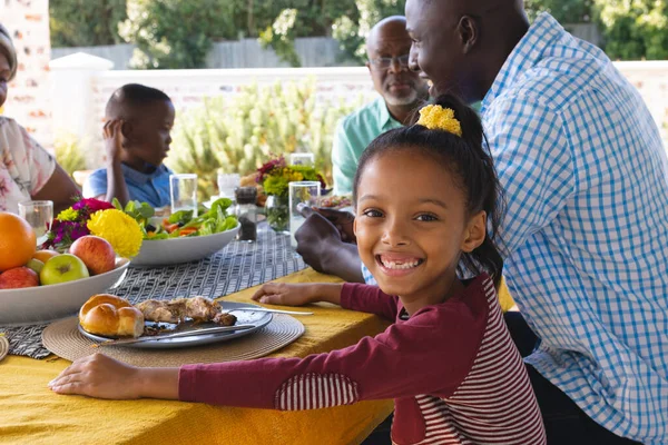 自宅のダイニングテーブルで多世代の家族とランチをした幸せな多人種の少女の肖像画 食べ物 変わらない 一緒に 子供時代 ライフスタイルと退職の概念 — ストック写真