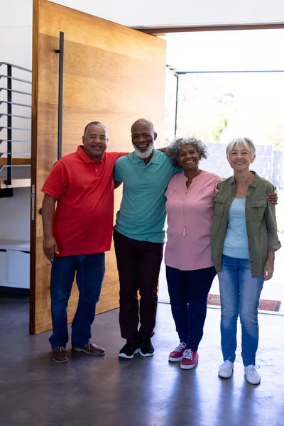 在疗养院门口站着的多种族老年朋友们抱着胳膊微笑的画像 保持不变 协助生活和退休 — 图库照片