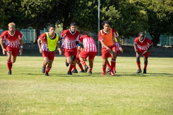 Multiraciale Mannelijke Voetballers Met Rode Sportuniformen Grasveld Speelplaats Ongewijzigd Voetbal — Stockfoto