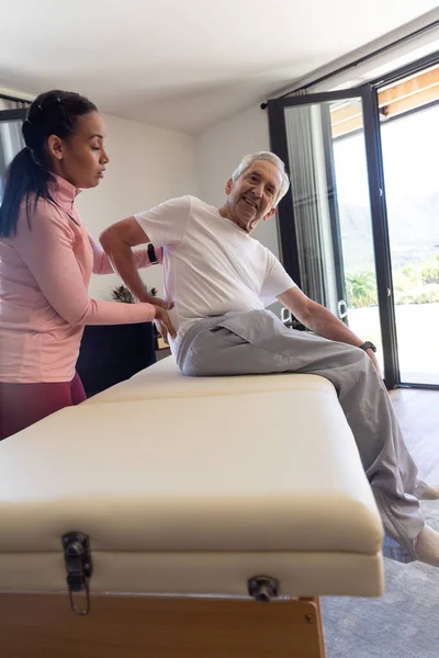 Fizioterapeutul Feminin Biracial Oferă Înapoi Terapia Masaj Unui Bărbat Vârstă — Fotografie, imagine de stoc