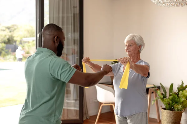 Afroameričtí Mužští Fyzioterapeuti Pomáhají Starší Ženě Cvičit Odbojovými Pásmy Zdravotní — Stock fotografie