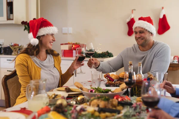 Kaukasisches Paar Das Gemeinsam Tisch Sitzt Weihnachtsmannmützen Trägt Weingläser Der — Stockfoto
