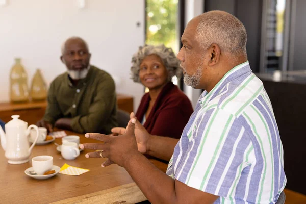 Hombre Sénior Multiracial Hablando Con Amigos Mientras Toma Café Galletas —  Fotos de Stock