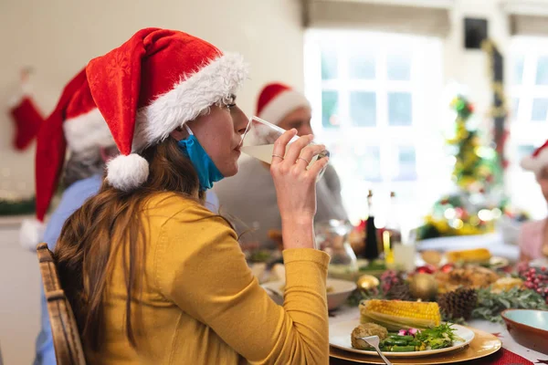 Mulher Caucasiana Sentada Mesa Para Jantar Usando Chapéu Papai Noel — Fotografia de Stock