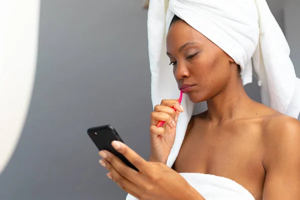 浴室のスマートフォンを点検しながら若いアフリカ系アメリカ人女性の歯をブラッシングし スペースをコピーします 変更されていない テクノロジー リラクゼーション 甘やかす デトックス ボディケアと健康の概念 — ストック写真