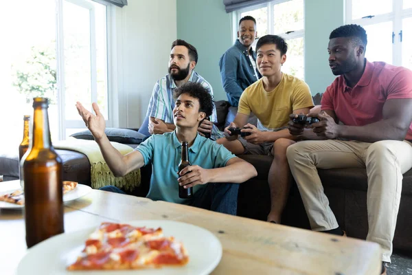 家庭で余暇を過ごしながらビデオゲームやビールを楽しむ男性多人種の友人 コピースペース アルコール ゲームコントローラ 変更されていない 一緒に 楽しさ 週末の活動 — ストック写真