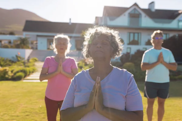 Wielorasowi Seniorzy Medytują Stojąc Przeciwko Domowi Spokojnej Starości Podwórku Słoneczny — Zdjęcie stockowe