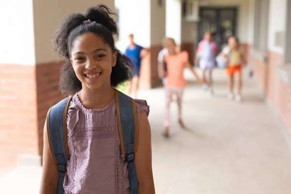 Portrait Cheerful Biracial Girl Wearing Backpack Standing School Corridor Copy — Stock Photo, Image