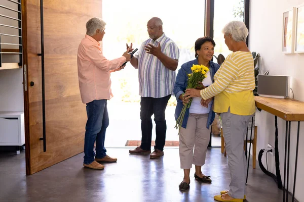 老人ホームで花束やシャンパンボトルと友人を受信出産高齢者 コピースペース 入り口 ゲスト 変更されていない サポート 生活と退職の概念を支援 — ストック写真
