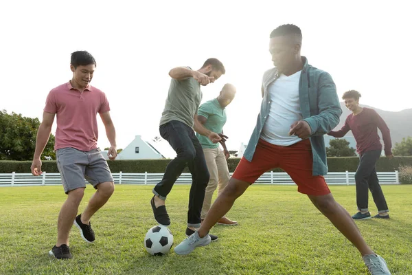 Multiracial Male Friends Playing Soccer Grassy Land Yard Clear Sky — Stock Photo, Image