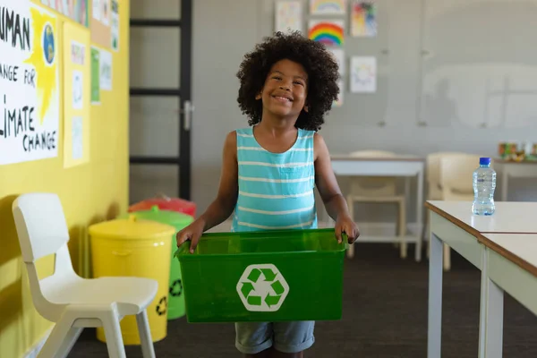 微笑着非洲裔美国小学生拿着装有回收符号的容器 环境清理 可持续生活方式和学校概念 — 图库照片