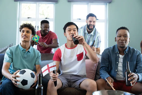 快乐的多种族男性朋友 带着球和啤酒瓶在家里沙发上看足球比赛 社交活动 娱乐和周末活动 — 图库照片