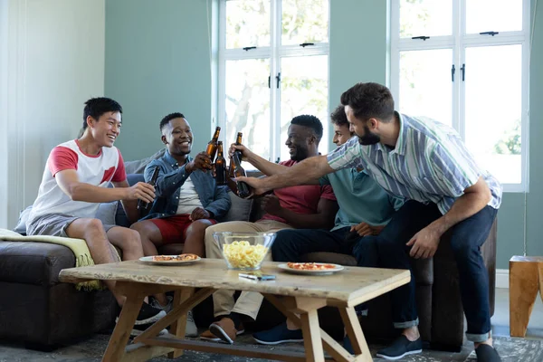 快乐的多种族男性朋友一边烘焙啤酒瓶 一边放松地躺在沙发上 模仿空间 娱乐和周末活动概念 — 图库照片