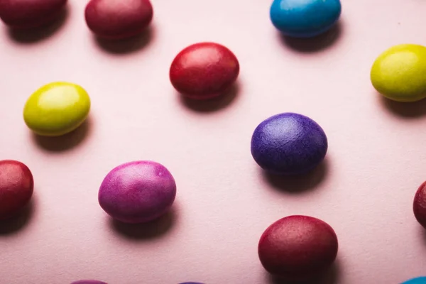 粉色背景的彩色巧克力糖果的高角特写 不变的 不健康的饮食和甜食概念 — 图库照片