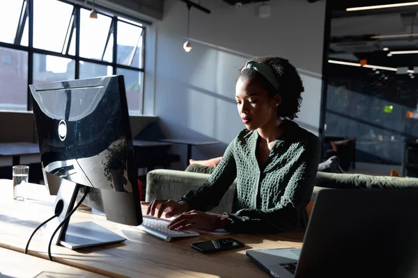 アフリカ系アメリカ人の若い実業家がオフィスでコンピュータを使っている 変更されていない創造的なビジネス — ストック写真