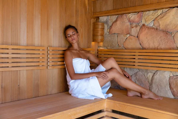 穿着浴衣的白人年轻女子在桑拿放松 健康和放松的概念 — 图库照片
