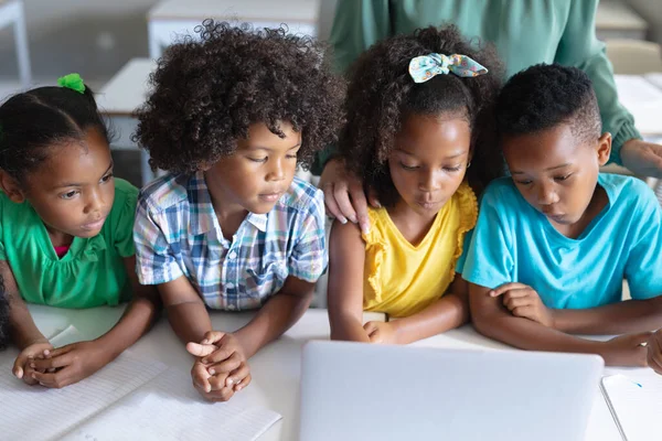 Afro Amerikaanse Elementaire Studenten Kijken Laptop Terwijl Achter Een Bureau — Stockfoto
