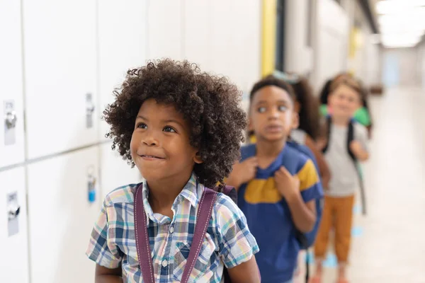 多种族的无辜小学生排成一排站在储物柜旁 儿童和学校概念 — 图库照片