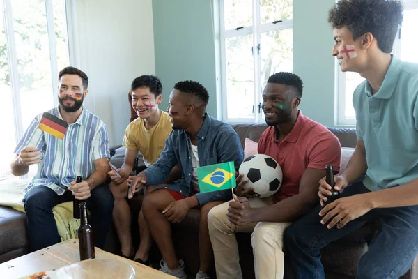 快乐的多种族男性朋友与旗帜 啤酒瓶 球观看比赛而坐在沙发上 社交活动 娱乐和周末活动 — 图库照片