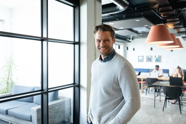 stock image Portrait of smiling caucasian mid adult businessman in creative office. Unaltered, creative business, workplace, occupation, positive emotion.