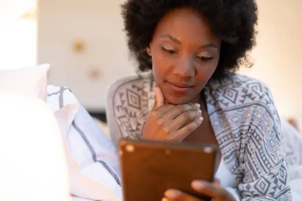 アフリカ系アメリカ人の若いアフロ女性が寝室に横たわっている間 デジタルタブレットを使用して スペースをコピーします 変化のない ライフスタイル テクノロジーの概念 — ストック写真