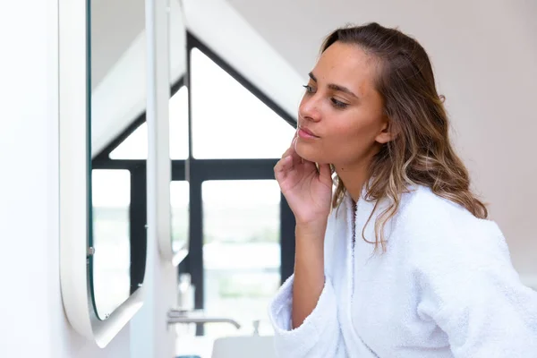 家で鏡を見てバスローブを着た白人女性 セルフケア リラクゼーションの概念 — ストック写真
