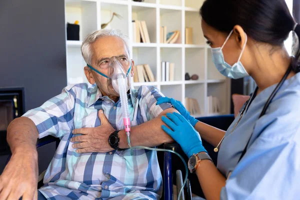 Biraciale Vrouwelijke Gezondheidswerker Helpt Kaukasische Senior Man Zuurstofmasker Thuis Gebruiken — Stockfoto
