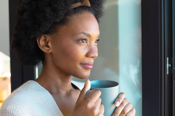 Przemyślana Młoda Afrykańska Afro Kobieta Odwracając Wzrok Pijąc Kawę Domu — Zdjęcie stockowe