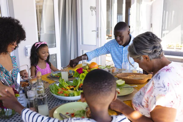 多种族多代家庭手牵着手 在午餐前在饭桌上说着优雅的话 饮食和家庭观念 — 图库照片