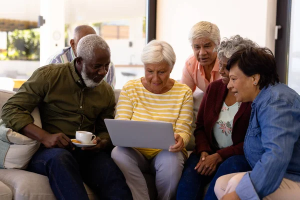 Wielorasowi Seniorzy Patrzą Przyjaciółkę Korzystającą Laptopa Siedząc Kanapie Domu Opieki — Zdjęcie stockowe