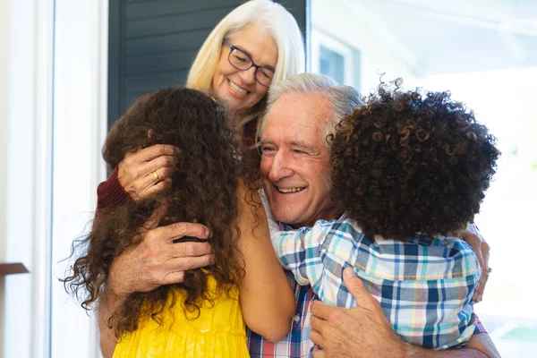 Nipotini Multirazziali Che Abbracciano Nonni Allegri Accolgono Casa All Ingresso — Foto Stock