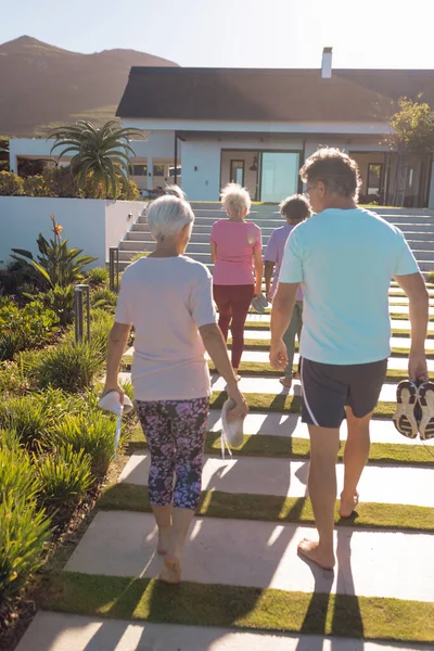 女性が夏に老人ホームに向かって歩いている多人種高齢者の背面図 変更されていない サポート 支援生活や退職の概念 — ストック写真