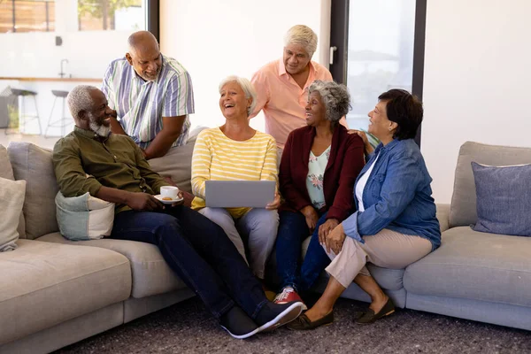 ラップトップを持つ多人種の幸せなシニア女性は 老人ホームでソファに座っています 無線技術 コーヒー 生活支援 退職の概念 — ストック写真