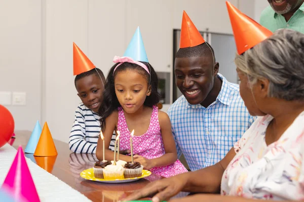 Мультирасовая Девушка Шляпе Вечеринок Задувает Свечи Время Празднования Дня Рождения — стоковое фото