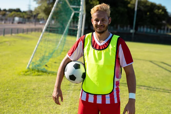 Portret Uśmiechniętego Białego Młodego Gracza Czerwonej Koszulce Piłką Nożną Stojącą — Zdjęcie stockowe