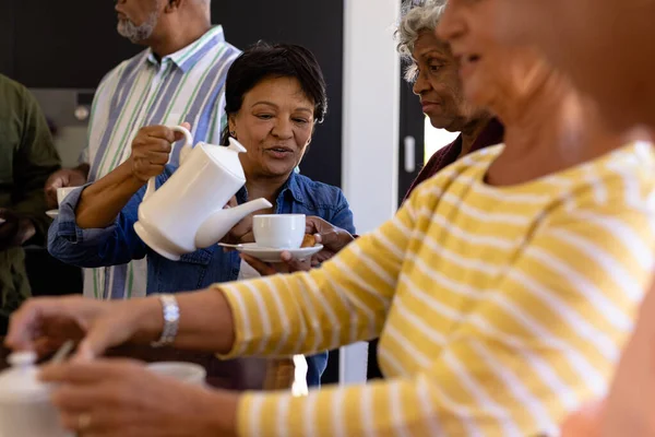 Biraciale Senior Vrouw Die Koffie Serveert Aan Multiraciale Vrienden Terwijl — Stockfoto