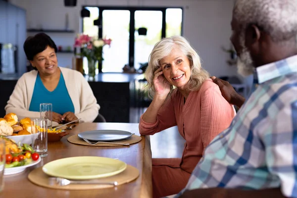 Fröhliche Multiethnische Seniorenfreunde Mit Essen Esstisch Während Sie Pflegeheim Sitzen — Stockfoto