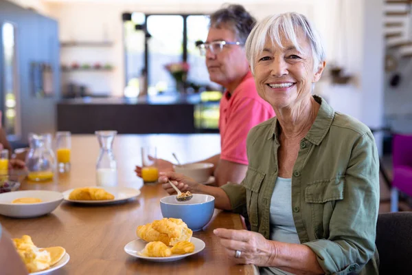 Portret Uśmiechniętej Azjatyckiej Starszej Kobiety Jedzącej Śniadanie Białym Mężczyzną Przy — Zdjęcie stockowe
