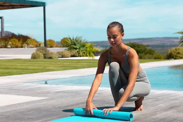 Beyaz Bir Kadın Yoga Minderini Havuz Kenarında Yuvarlıyor Fitness Sağlıklı — Stok fotoğraf