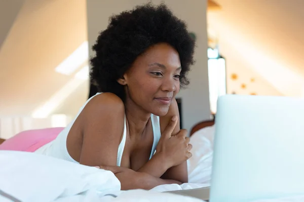 アフリカの若いアフリカ系アメリカ人女性がベッドルームのノートパソコンでビデオを見て スペースをコピーします 変化のない ライフスタイル テクノロジーの概念 — ストック写真